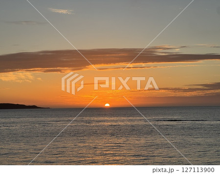 水平線に沈む太陽と夕焼けの空 水平線に沈む太陽と夕焼けの空 127113900