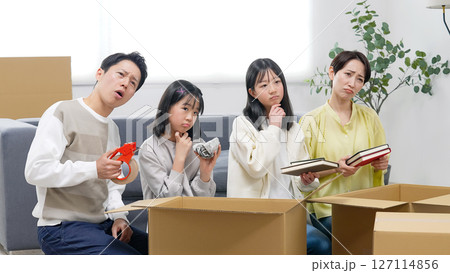 家で荷造り・荷解きしながら悩む家族 127114856