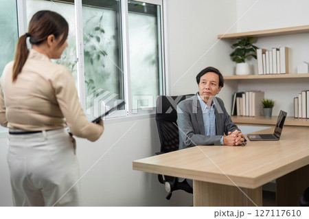 Business Consultation and Presentation. Professional discussing data insights in a modern office. Business Consultation and Presentation. Professional discussing data insights in a modern office. 127117610