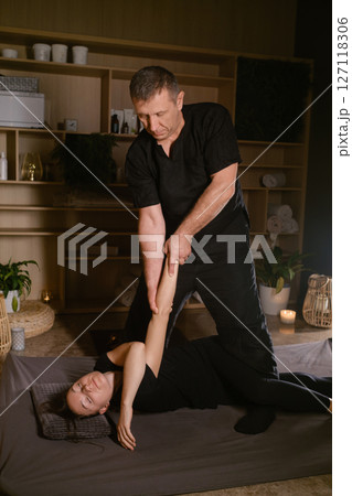 Professional masseur gives Girl Thai massage in massage parlor. Traditional Asian stretching therapy Professional masseur gives Girl Thai massage in massage parlor. Traditional Asian stretching therapy 127118306