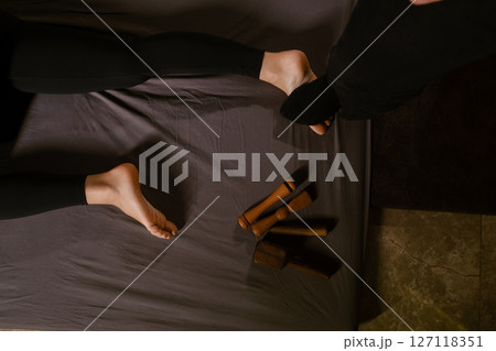 A man gives a relaxing Thai foot massage with a Tok-Sen massage kit at a beauty spa. Body care A man gives a relaxing Thai foot massage with a Tok-Sen massage kit at a beauty spa. Body care 127118351