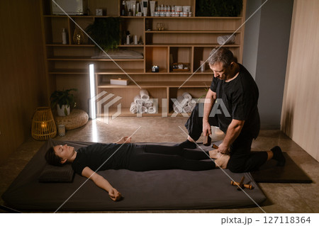 Massage therapist performs a relaxing Thai foot massage using a Tok-Sen massage set at the spa. Body care Massage therapist performs a relaxing Thai foot massage using a Tok-Sen massage set at the spa. Body care 127118364