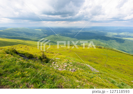 beautiful view in to the valley from the mountain top. green hills and meadows. travel through carpathian range. sunny weather in summer with cloudy sky beautiful view in to the valley from the mountain top. green hills and meadows. travel through carpathian range. sunny weather in summer with cloudy sky 127118593