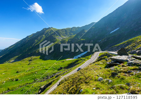 romania travel landscape with road in summer. beautiful mountain road that crosses southern carpathians. touristic destination of europe. sunny day with blue sky and fluffy clouds 127118595