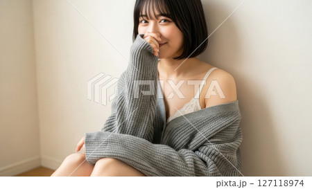 壁際に座って笑顔を見せる日本人下着モデルのポートレート 127118974