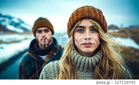 A man and a woman standing next to each other in the snow 127119745