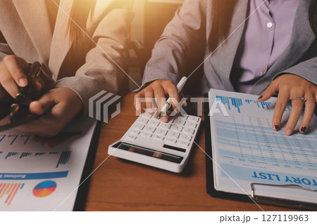 Group of confident business people point to graphs and charts to analyze market data, balance sheet, account, net profit to plan new sales strategies to increase production capacity. 127119963