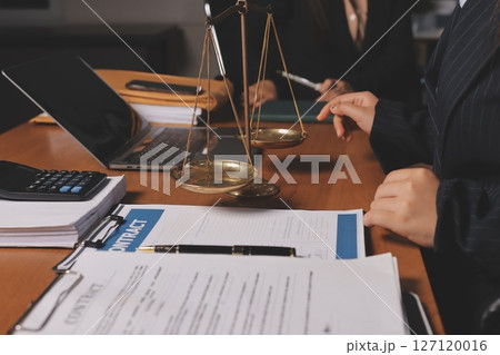 Attractive young lawyer in office Business woman and lawyers discussing contract papers with brass scale on wooden desk in office. Law, legal services, advice, Justice and real estate concept. 127120016