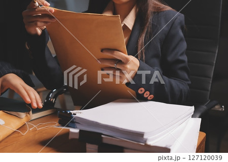 Attractive young lawyer in office Business woman and lawyers discussing contract papers with brass scale on wooden desk in office. Law, legal services, advice, Justice and real estate concept. 127120039