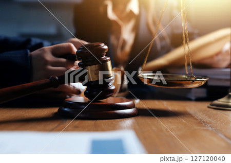 Attractive young lawyer in office Business woman and lawyers discussing contract papers with brass scale on wooden desk in office. Law, legal services, advice, Justice and real estate concept. Attractive young lawyer in office Business woman and lawyers discussing contract papers with brass scale on wooden desk in office. Law, legal services, advice, Justice and real estate concept. 127120040
