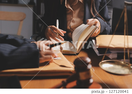 Attractive young lawyer in office Business woman and lawyers discussing contract papers with brass scale on wooden desk in office. Law, legal services, advice, Justice and real estate concept. Attractive young lawyer in office Business woman and lawyers discussing contract papers with brass scale on wooden desk in office. Law, legal services, advice, Justice and real estate concept. 127120041