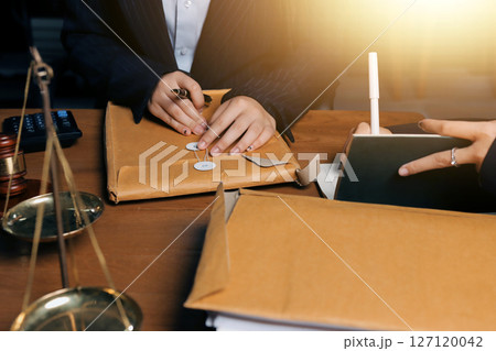 Attractive young lawyer in office Business woman and lawyers discussing contract papers with brass scale on wooden desk in office. Law, legal services, advice, Justice and real estate concept. Attractive young lawyer in office Business woman and lawyers discussing contract papers with brass scale on wooden desk in office. Law, legal services, advice, Justice and real estate concept. 127120042