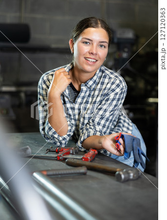 Young woman posing in metallurgical workshop 127120363