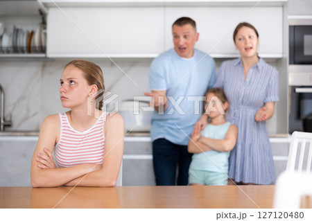 At home kitchen parents scold sitting child for bad behavior at school 127120480