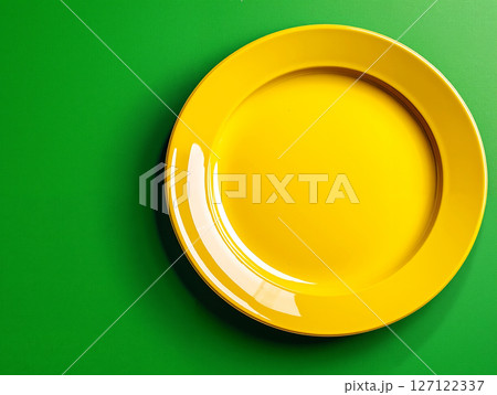 A yellow plate on a green background A yellow plate on a green background 127122337