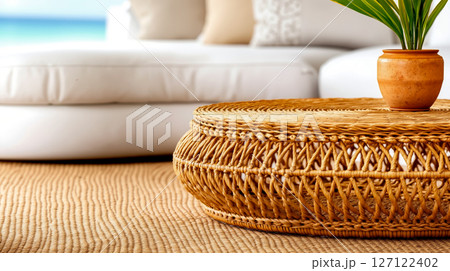 A wicker coffee table with a potted plant on top of it 127122402
