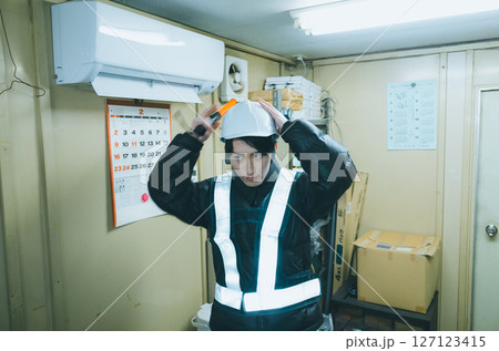 警備事務所の更衣室で支度をする警備員バイト 警備事務所の更衣室で支度をする警備員バイト 127123415