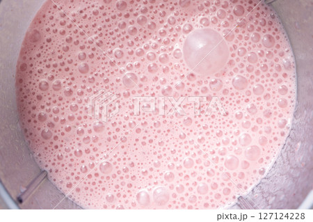 Strawberry milkshake with bubbles on the surface, close-up, top view. Strawberry milkshake with bubbles on the surface, close-up, top view. 127124228
