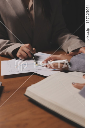 Group of confident business people point to graphs and charts to analyze market data, balance sheet, account, net profit to plan new sales strategies to increase production capacity. Group of confident business people point to graphs and charts to analyze market data, balance sheet, account, net profit to plan new sales strategies to increase production capacity. 127125064