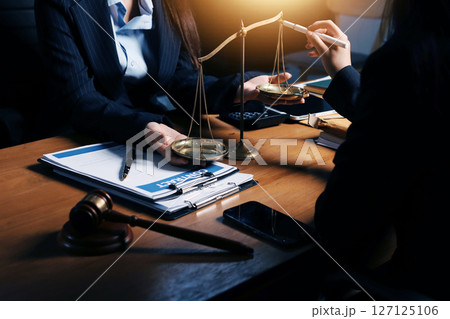 Attractive young lawyer in office Business woman and lawyers discussing contract papers with brass scale on wooden desk in office. Law, legal services, advice, Justice and real estate concept. Attractive young lawyer in office Business woman and lawyers discussing contract papers with brass scale on wooden desk in office. Law, legal services, advice, Justice and real estate concept. 127125106