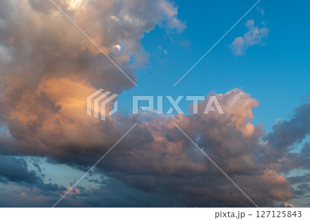 Dramatic evening sky with colorful clouds and blue background. 127125843