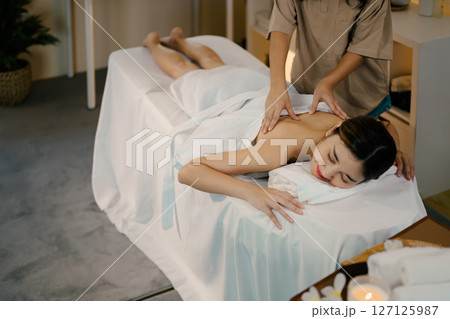 Relaxed lady enjoy body massage at spa with closed eyes. Wellness concept 127125987