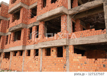Unfinished building and construction site with red bricks 127127507