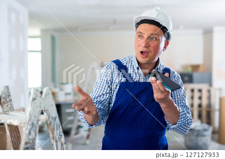 Foreman using smartphone, recording voice message 127127933