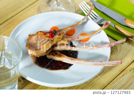 Baked under tasty lamb ribs served with sauce and carrots Baked under tasty lamb ribs served with sauce and carrots 127127983