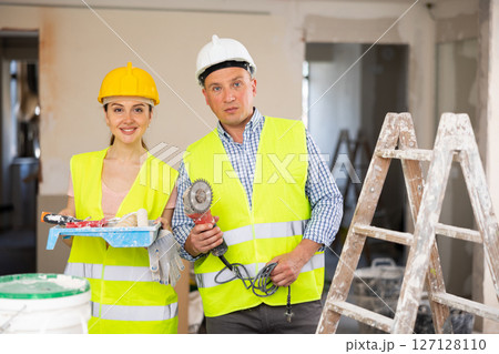 Two workers posing on indoor construction site Two workers posing on indoor construction site 127128110