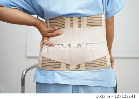 Asian woman wearing lumbar support pain back and use walker in hospital. Asian woman wearing lumbar support pain back and use walker in hospital. 127128241