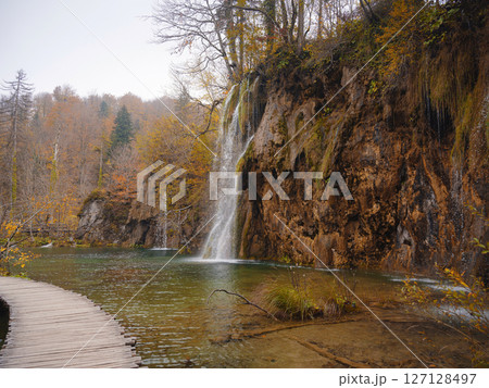 Wooden walkpath in Plitvice National Park. Splendid autumn in forest with pure water lake. Picturesque landscape of Croatia, Europe. Beauty of nature concept background. Wooden walkpath in Plitvice National Park. Splendid autumn in forest with pure water lake. Picturesque landscape of Croatia, Europe. Beauty of nature concept background. 127128497