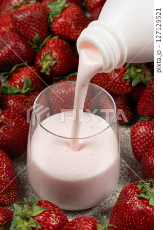 Milk drinking strawberry sweet yogurt poured from bottle to glass. Milk drinking strawberry sweet yogurt poured from bottle to glass. 127129521
