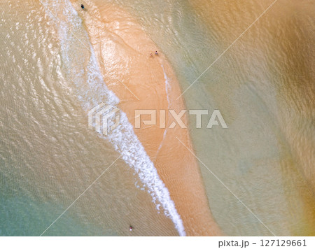Top view beach with waves crashing on sandy shore,Beautiful waves sea surface in summer seascape background,Amazing beach colorful water background 127129661