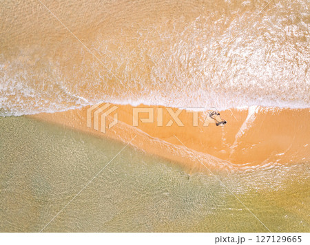 Top view beach with waves crashing on sandy shore,Beautiful waves sea surface in summer seascape background,Amazing beach colorful water background Top view beach with waves crashing on sandy shore,Beautiful waves sea surface in summer seascape background,Amazing beach colorful water background 127129665