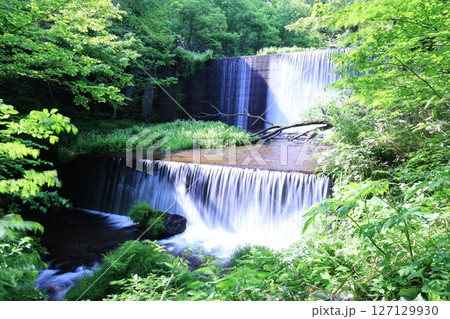 緑の中にある人工的な構造物の上を流れる川の水 127129930