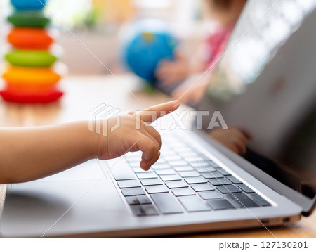 ノートパソコンを操作する子供の手元 127130201