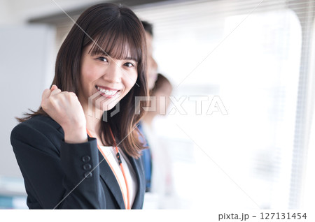 ガッツポーズする若いスーツ姿の女性 127131454