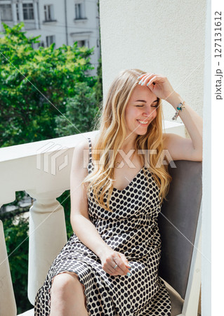 Beautiful blonde woman in summer dress smiling 127131612