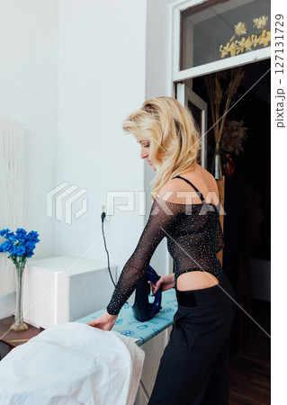 Beautiful fashionable blonde ironing clothes on a board Beautiful fashionable blonde ironing clothes on a board 127131729