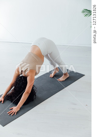 Fitness Woman Brunette Doing Gymnastics Yoga Asana in White Hall Fitness Woman Brunette Doing Gymnastics Yoga Asana in White Hall 127131826