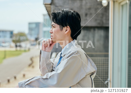 外を見つめながら考える若い男性 127131927