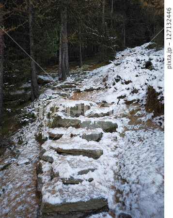 Stone steps lead through a snowy forest in aosta, italy, capturing the serene beauty of winter with trees lining the tranquil path Lillaz 127132446