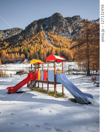 Colorful playground equipment standing amid snowy landscape, framed by autumn foliage and mountain terrain in aosta valley, italy Frazionne Lillaz Colorful playground equipment standing amid snowy landscape, framed by autumn foliage and mountain terrain in aosta valley, italy Frazionne Lillaz 127132456