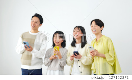 笑顔でスマホを使う女の子家族　ぼかしイメージ 127132871