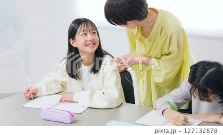 勉強する二人の女の子と女性教員 勉強する二人の女の子と女性教員 127132878