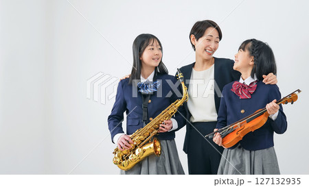 サックスとバイオリンを持った女子学生グループと女性教師 127132935