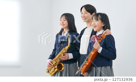 サックスとバイオリンを持った女子学生グループと女性教師 127132936