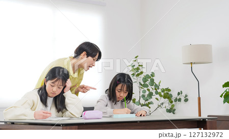 勉強する二人の女の子と厳しく指導する女性 127132972