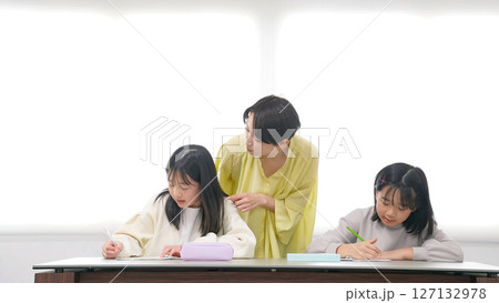 勉強する二人の女の子と女性教員 勉強する二人の女の子と女性教員 127132978